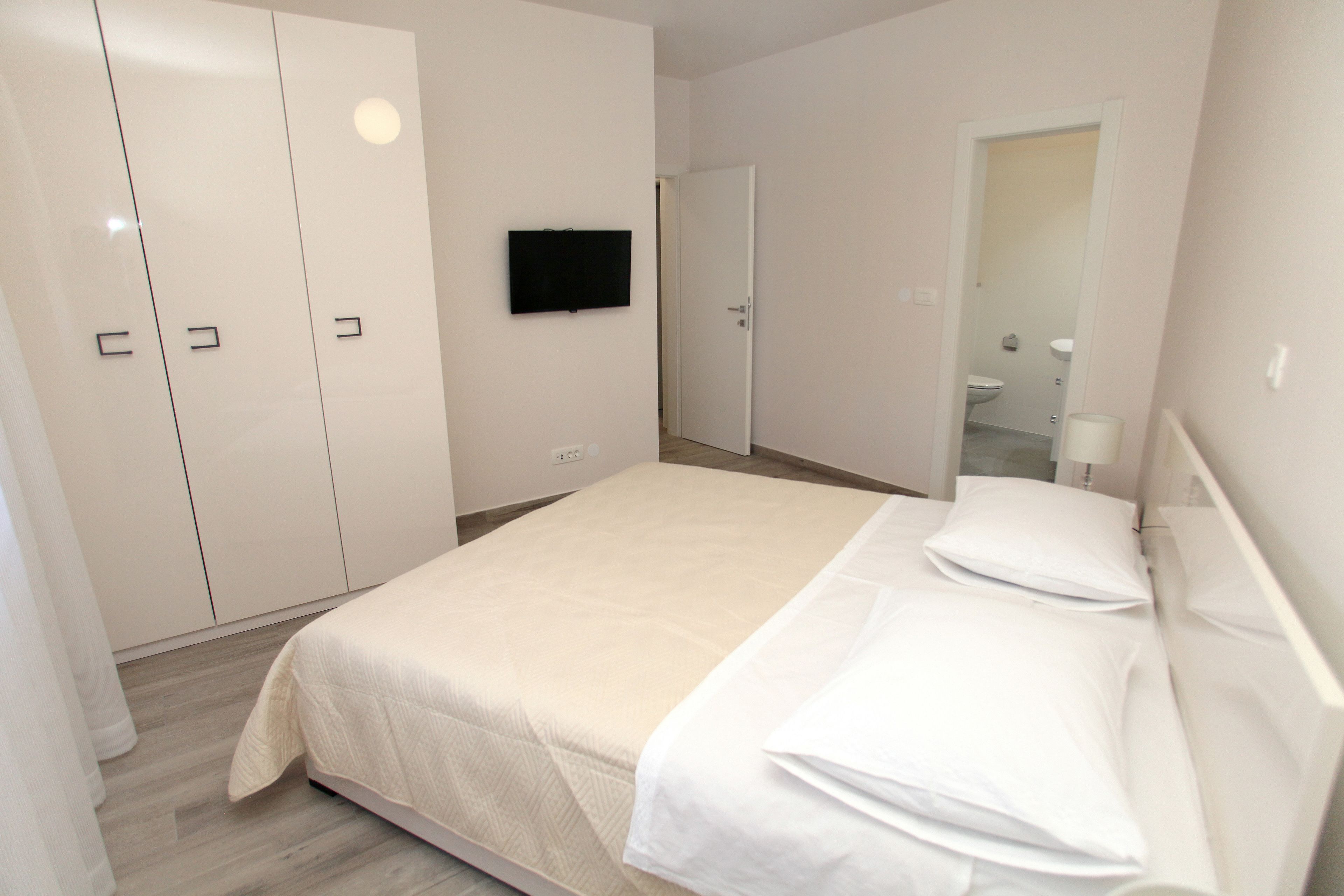 Una camera da letto con un letto, una televisione e un armadio.
