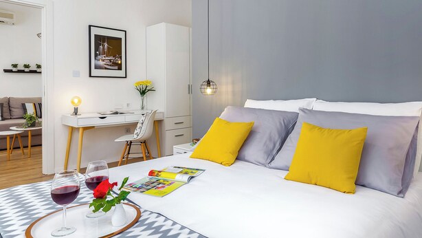 A modern bedroom with a bed, bedside table, and a desk with a chair. - Rijeka Apartments Terra City Center (Rijeka)