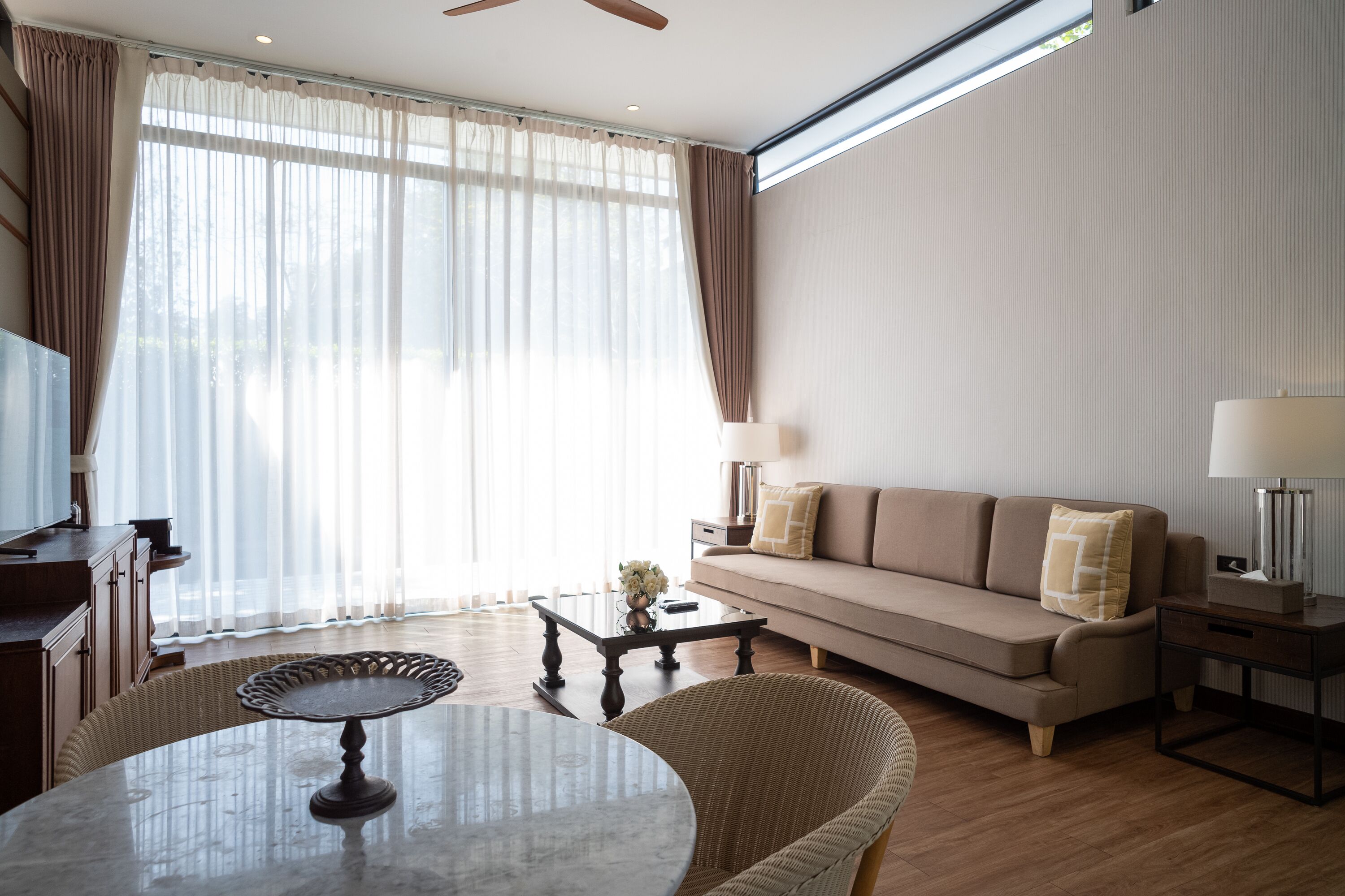 A modern living room with a sofa, coffee table, and a dining table.