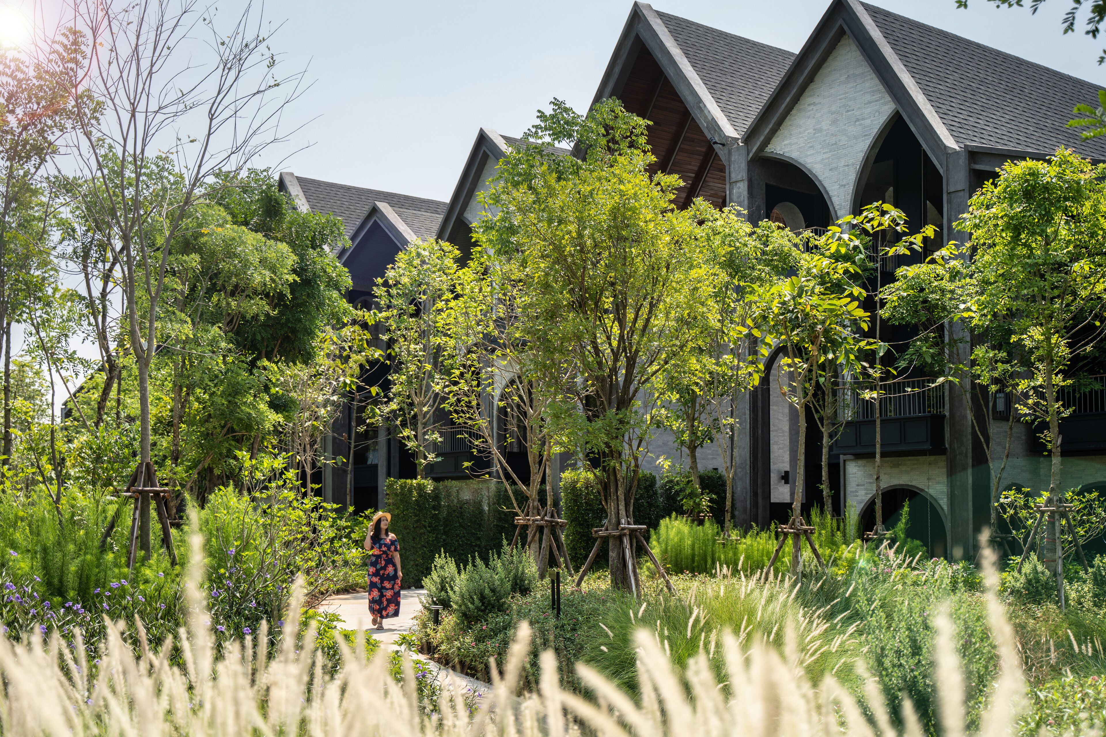 A modern building with multiple gabled roofs and a central courtyard with trees and a pathway.