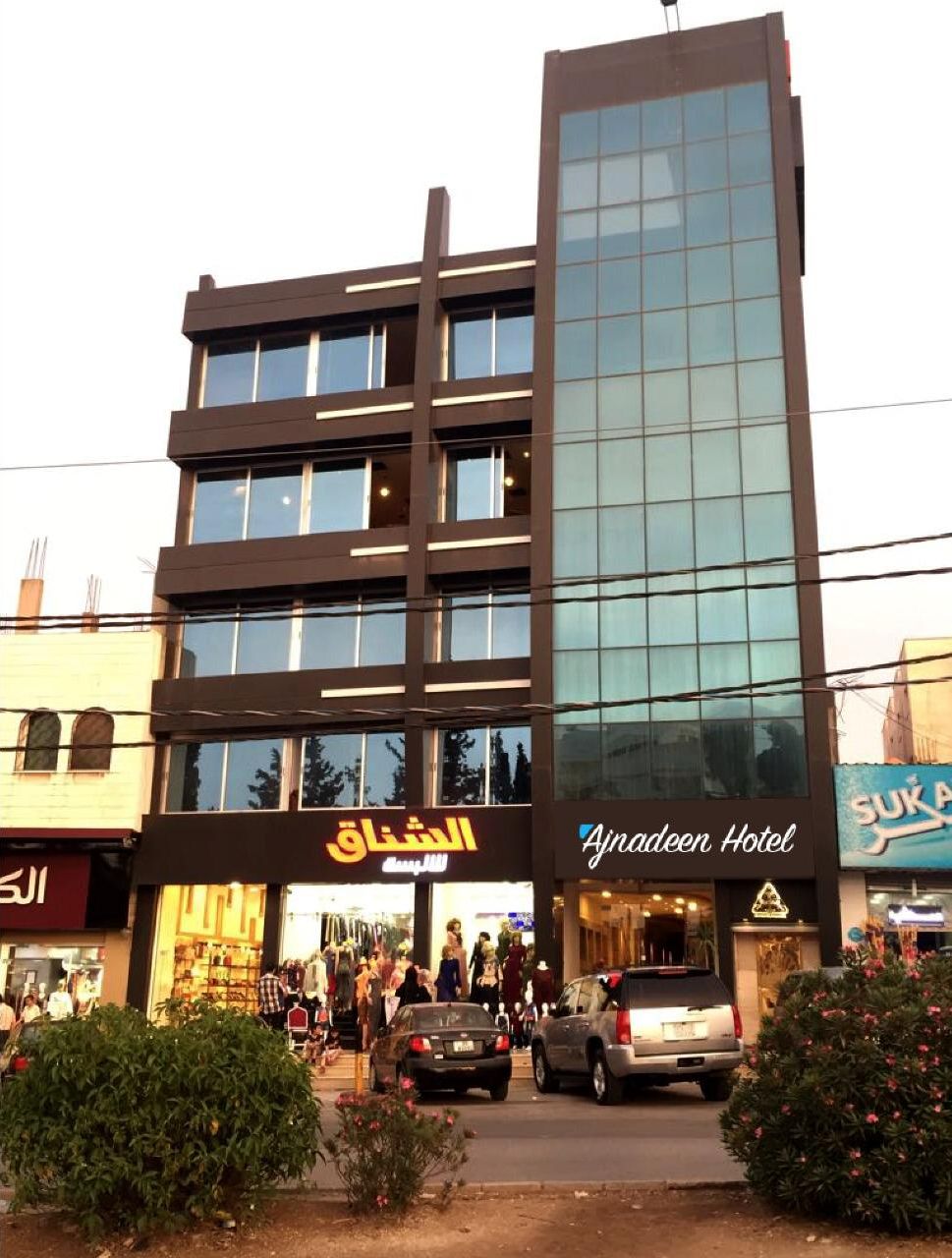 A modern building with multiple floors, featuring a glass facade and a ground-level entrance.