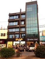 Un edificio moderno con varios pisos, con fachada de vidrio y entrada a nivel de calle.