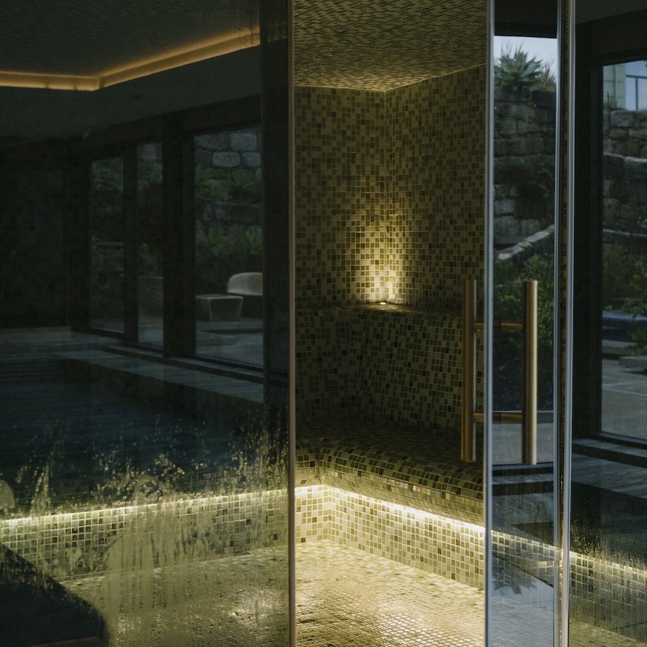 A modern interior with a glass partition, a tiled floor, and a view of the outdoors.