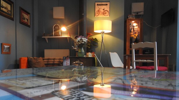A room with a glass table displaying a map, a lamp, a chair, and a radiator. - Hull Trinity Backpackers (Hull)