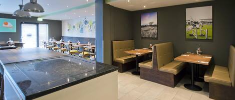 A restaurant with a central island, booths, and high chairs.