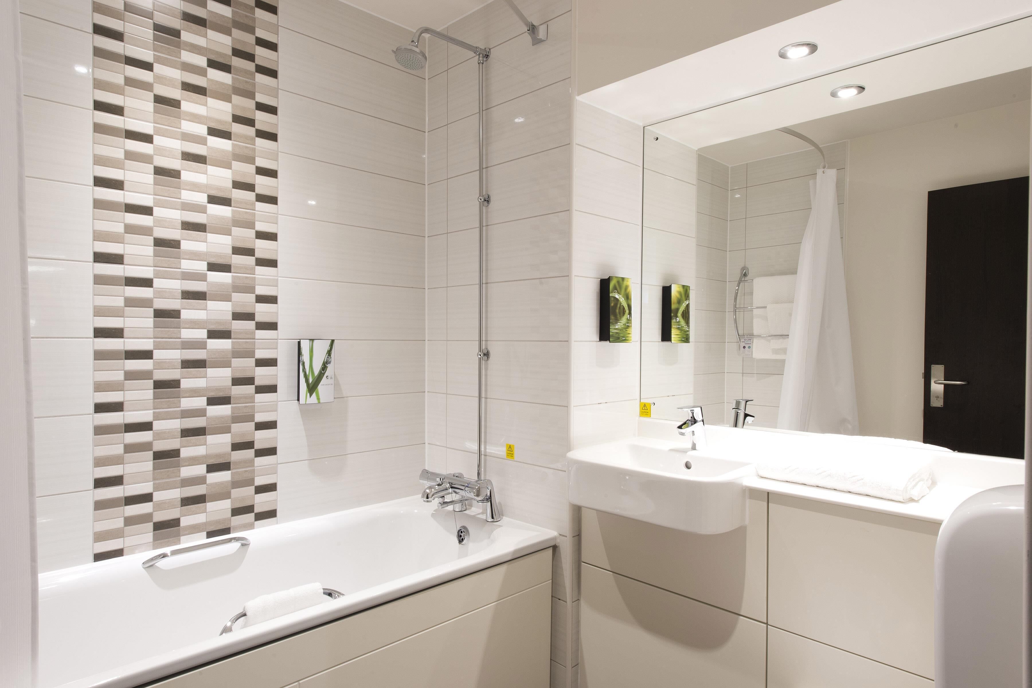 Un baño moderno con bañera, lavamanos y ducha.