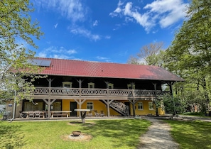 A two-story building with a red-tiled roof, a balcony, and a staircase leading to the upper floor. - Adelinenhof (Burg (Spreewald))