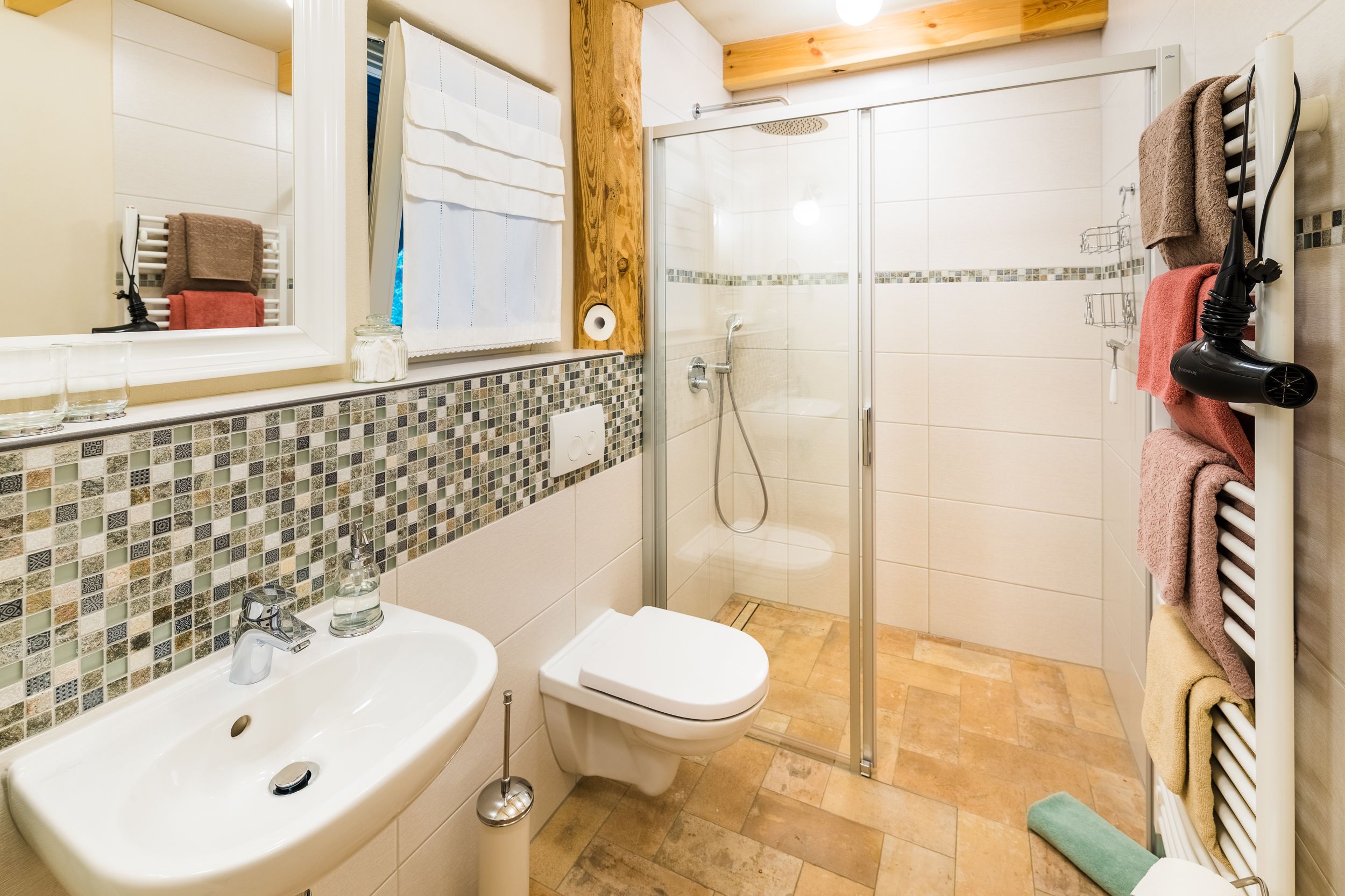 Ein Badezimmer mit Waschbecken, Toilette und Duschkabine aus Glas.
