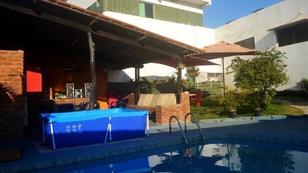 A swimming pool area with a covered seating area, a blue pool table, and a brick structure. - Hotel Bellavista (Bonito)
