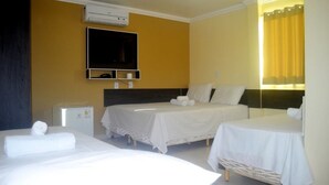 A hotel room with two beds, a flat-screen TV, a small refrigerator, and a window with curtains. - Hotel Bellavista (Bonito)