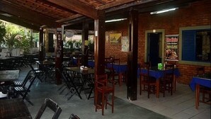 An indoor dining area with brick walls, wooden tables, and chairs. - Hotel Bellavista (Bonito)
