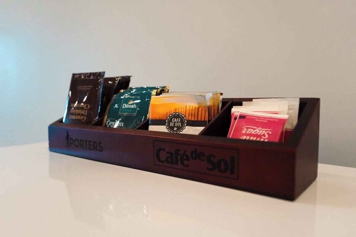 Uma bandeja com cápsulas de café e uma xícara.