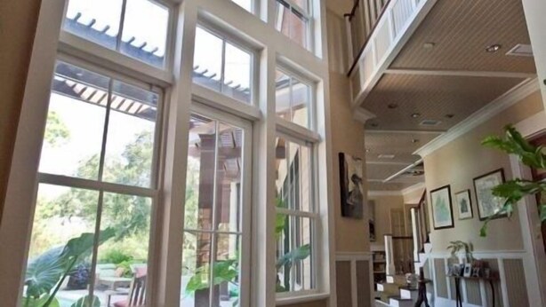 Un intérieur spacieux avec de grandes fenêtres, un sol en pierre et un plafond haut.