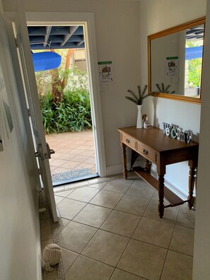A bathroom with a wooden vanity, a mirror, and a welcome sign.