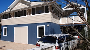 A two-story house with a garage, a covered porch, and a car parked in the driveway. - The Old Boathouse - kayak / high speed internet / minutes to the beach (Burrill Lake)