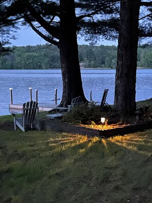 A lakeside setting with a dock, chairs, and a campfire. - Waterfront Home with Stunning Views .. Dog friendly , and great fishing !!! (Douglas)