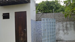 A small, enclosed outdoor area with a tiled wall, a metal gate, and a wooden door. - Beach house with leisure area and deserted beach with natural pools. (sao miguel dos milagres)
