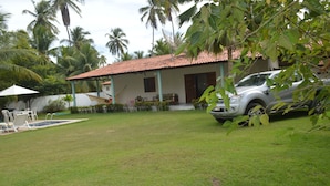 A house with a tiled roof, a swimming pool, and a car parked in the driveway. - Beach house with leisure area and deserted beach with natural pools. (sao miguel dos milagres)