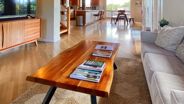 A spacious living area with a wooden ceiling, a dining area, and a kitchen.