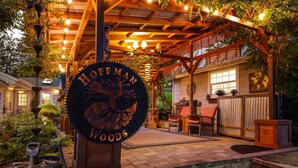 A wooden pergola with string lights, a sign reading "Hoffman Woods", and outdoor seating. - Go BeyOnd Ordinary & Escape to this Magnificent Wine Country Retreat, Golf, Hot Tub, Close to PDX (West Linn)