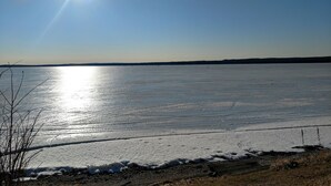 A frozen lake with a clear sky and distant land. - Large  Lakefront Home on Burt Lake, ICE FISHING Hunting, fishing snow sking golf (Cheboygan)