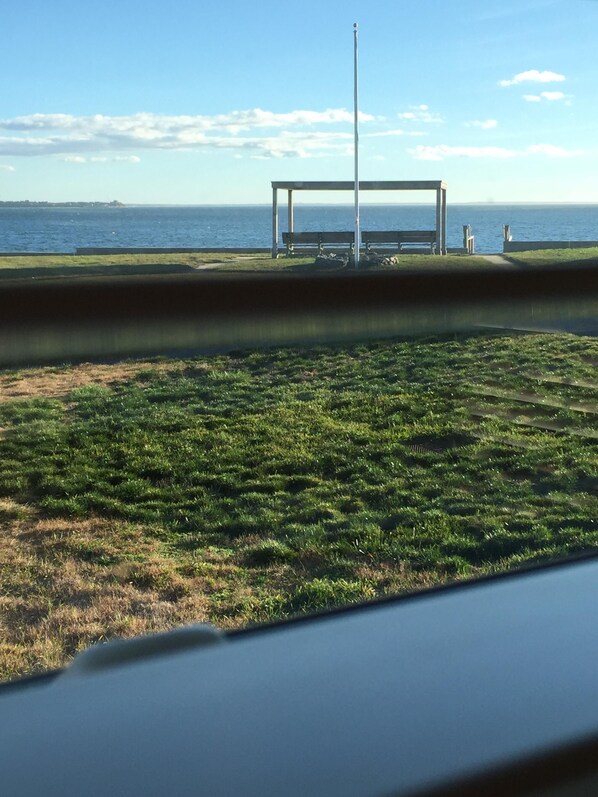 A grassy area with a metal structure and benches, overlooking a body of water. - Seaside Cozy Wellfleeter Cottage on Mayo Beach with 400 feet of private beach (Wellfleet)