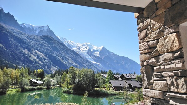 A mountain view with a lake and houses in the foreground.