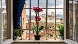 A window with a view of a cityscape, including buildings and a tower. - A Fantabulous Dreaming Terrace in FLORENCE Ponte Vecchio (Firenze)