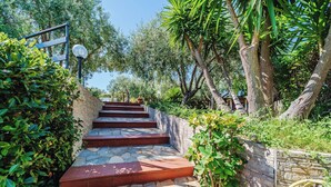 A stone staircase with red steps leading up to a building, surrounded by greenery and trees. - Villa with exclusive swimming pool 5 minutes from the sea (Palermo)
