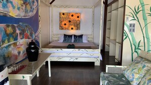 A bedroom with a four-poster bed, a wall-mounted clock, and a large abstract painting.