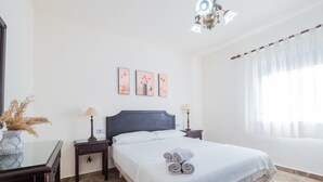 Un dormitorio con una cama, dos mesitas de noche, una lámpara de pared y una lámpara del techo.
