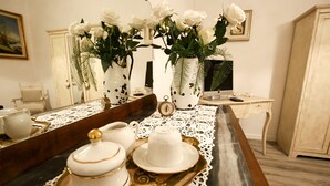 A dining table with white teapots and cups, a tray, and a vase with white roses. - SHABBY HOUSE GRANDMA PEPPA (Campello Sul Clitunno)