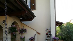 A house with a stone facade, a wooden fence, and a gravel pathway leading to the entrance. - SHABBY HOUSE GRANDMA PEPPA (Campello Sul Clitunno)