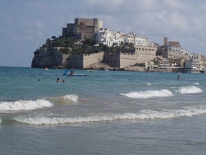 A coastal town with a prominent castle-like structure on a cliff overlooking the sea.