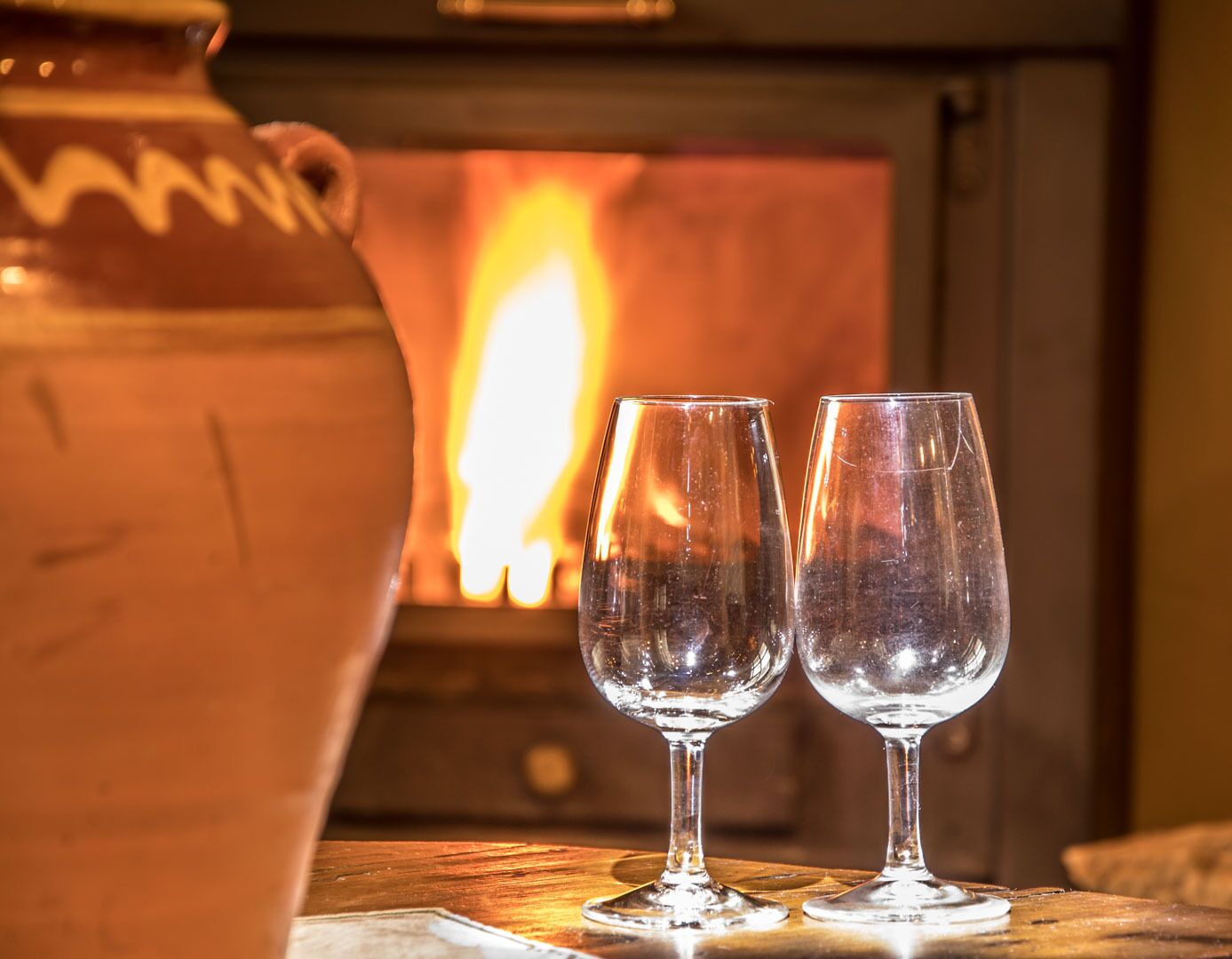 Una chimenea con dos copas de vino frente a ella.