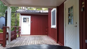 A red wooden building with a white door and a small window. - Holiday home in the woods included Rowing boat - lake with jetty    (Vimmerby)