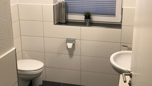 Un bagno piccolo e pulito con il water, un lavandino e una finestra.