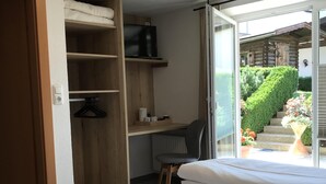 A bedroom with a bed, a desk, a chair, a TV, and a wardrobe. - Wittner's B&B - small, fine and warm (Söll)