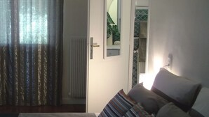 A bedroom with a bed, a bedside table, a mirror, and a window with curtains. - Fully furnished holiday apartment 4 * rated - very pleasant - 700 sq feet (Chambéry)