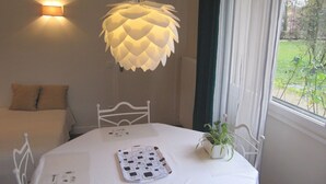 A bedroom with a bed, a bedside table, a lamp, and a window with a view of greenery. - Fully furnished holiday apartment 4 * rated - very pleasant - 700 sq feet (Chambéry)