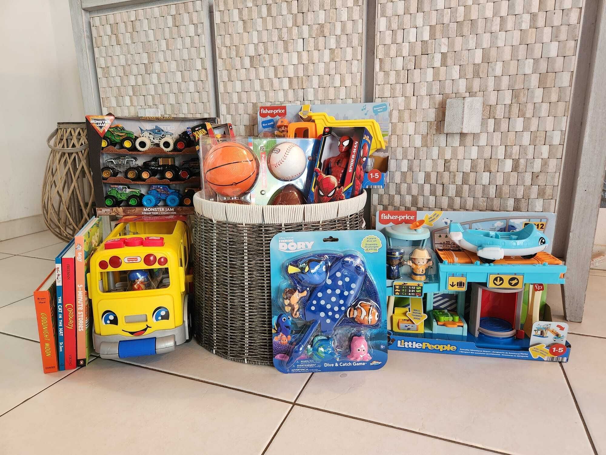 Verschiedene Kinderspielzeuge und Bücher liegen auf einem gefliesten Boden.