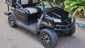 A golf cart parked on a paved area with lush greenery in the background. - As seen on HGTV's Bahamas Life - Perfect Villa for an Island Getaway! (Paradise Island, Nassau)