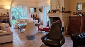 Un salón comedor amplio con chimenea y vistas al jardín.