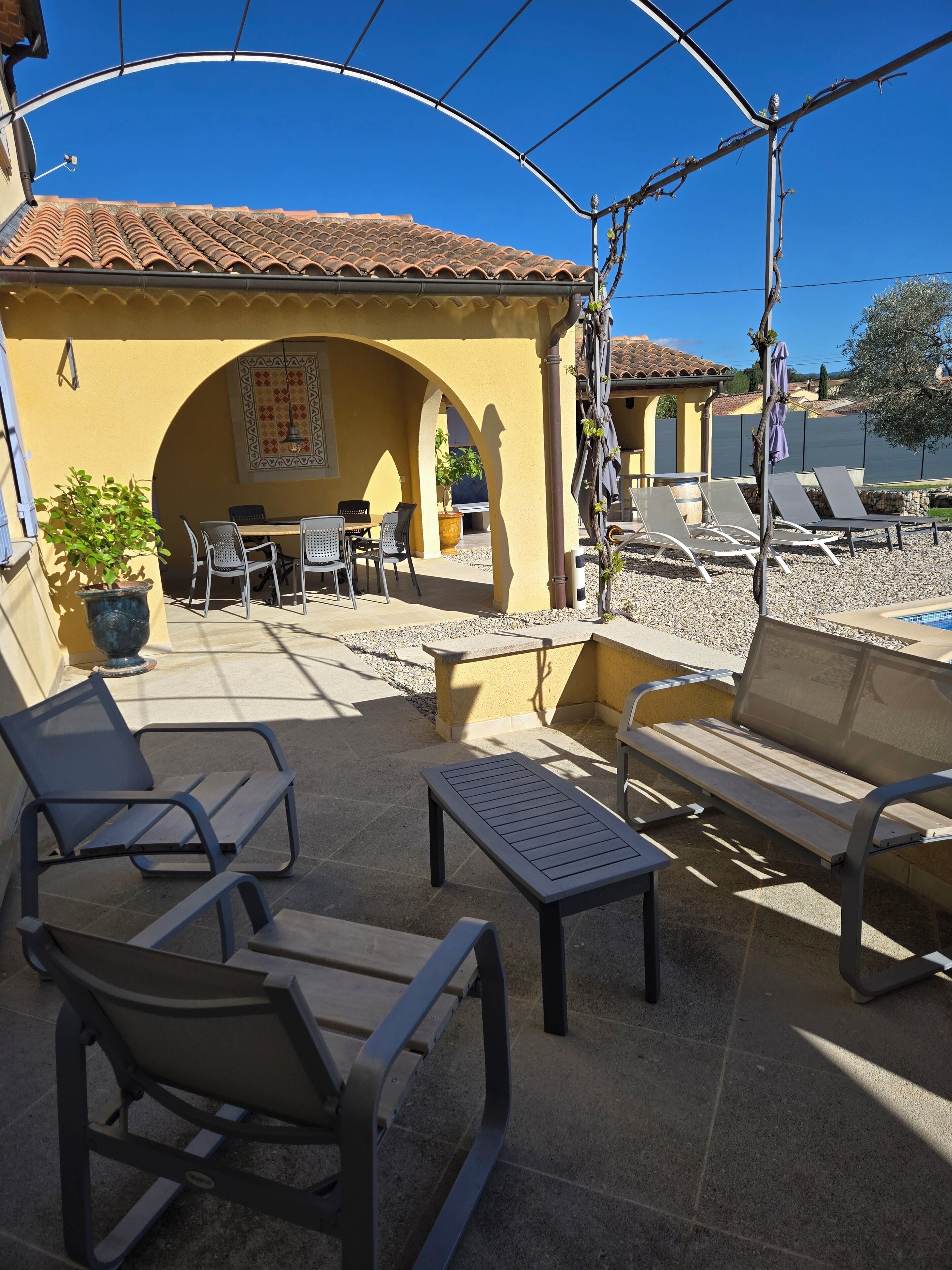 An outdoor patio area with seating, a table, and a view of a body of water.