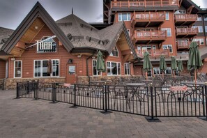 A lodge with outdoor seating and a fenced patio area.