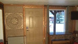 Una habitación con puerta de madera, un banco, un radiador y una pared con diseño.