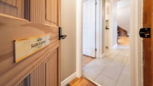 L’entrée d’un hôtel, avec une enseigne indiquant « Suite Cartier ».