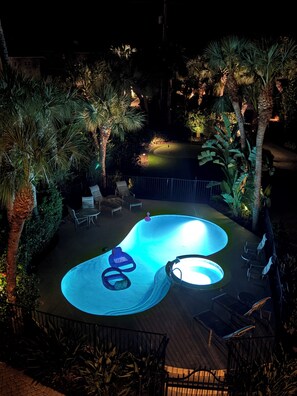 A swimming pool with a unique design, surrounded by palm trees and outdoor furniture. - September SPECIALS! Spectacular Sunrises and Sunsets! Pool/Hot Tub/putting green (Nokomis)