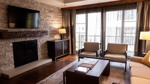 A modern living room with a stone wall, fireplace, comfortable seating, and large windows. - New Listing!! Ritz-Carlton At Vail Lion's Head Village!  Luxurious ski vacation! (Vail)