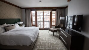 A hotel room with a large bed, a desk with a TV, a chair, and a window with a view of buildings. - New Listing!! Ritz-Carlton At Vail Lion's Head Village!  Luxurious ski vacation! (Vail)